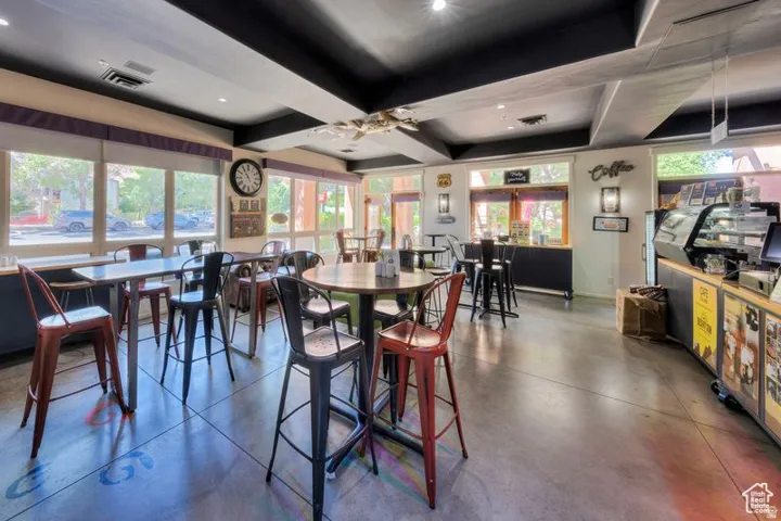 Spacious interior with concrete flooring and exposed ceiling beams