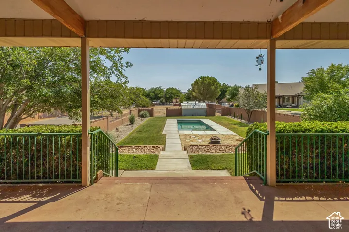 Expansive backyard with a rectangular inground swimming pool, concrete patio, and a manicured lawn
