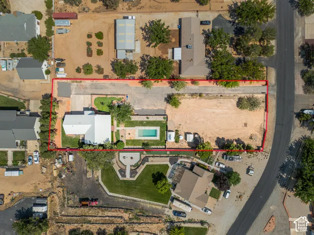 Property featuring a central residence, swimming pool, and expansive undeveloped land