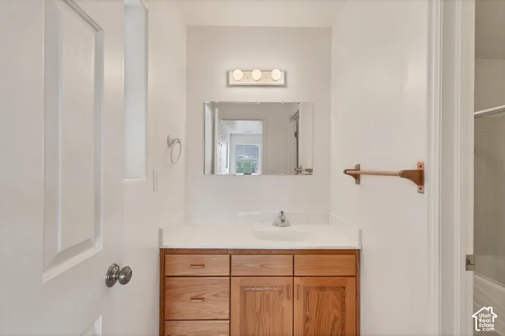 Wood-finish vanity with a white countertop and an integrated sink