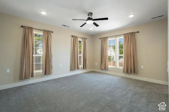 Spacious primary suite bathed in natural light through three sets of glass doors opening to outdoor space