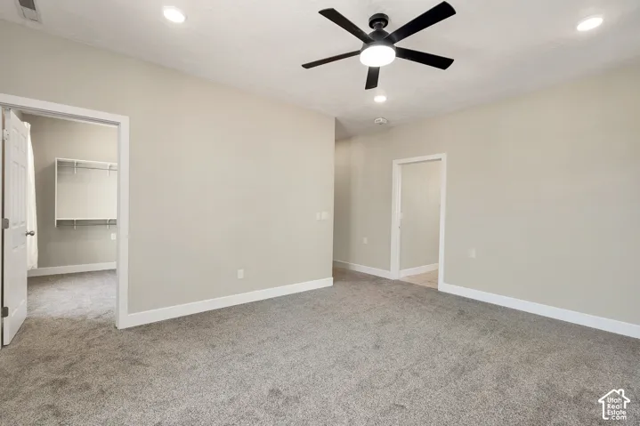 Primary suite with Neutral-toned walls, recessed lighting, and a ceiling fan with integrated light