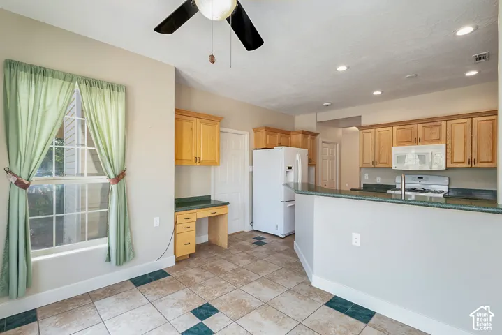 Kitchen featuring wood cabinetry, tiled flooring, recessed lighting, and a built-in desk area