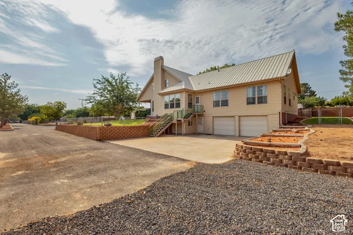 Two-story residence with a metal roof, two-car garage, and a retaining wall