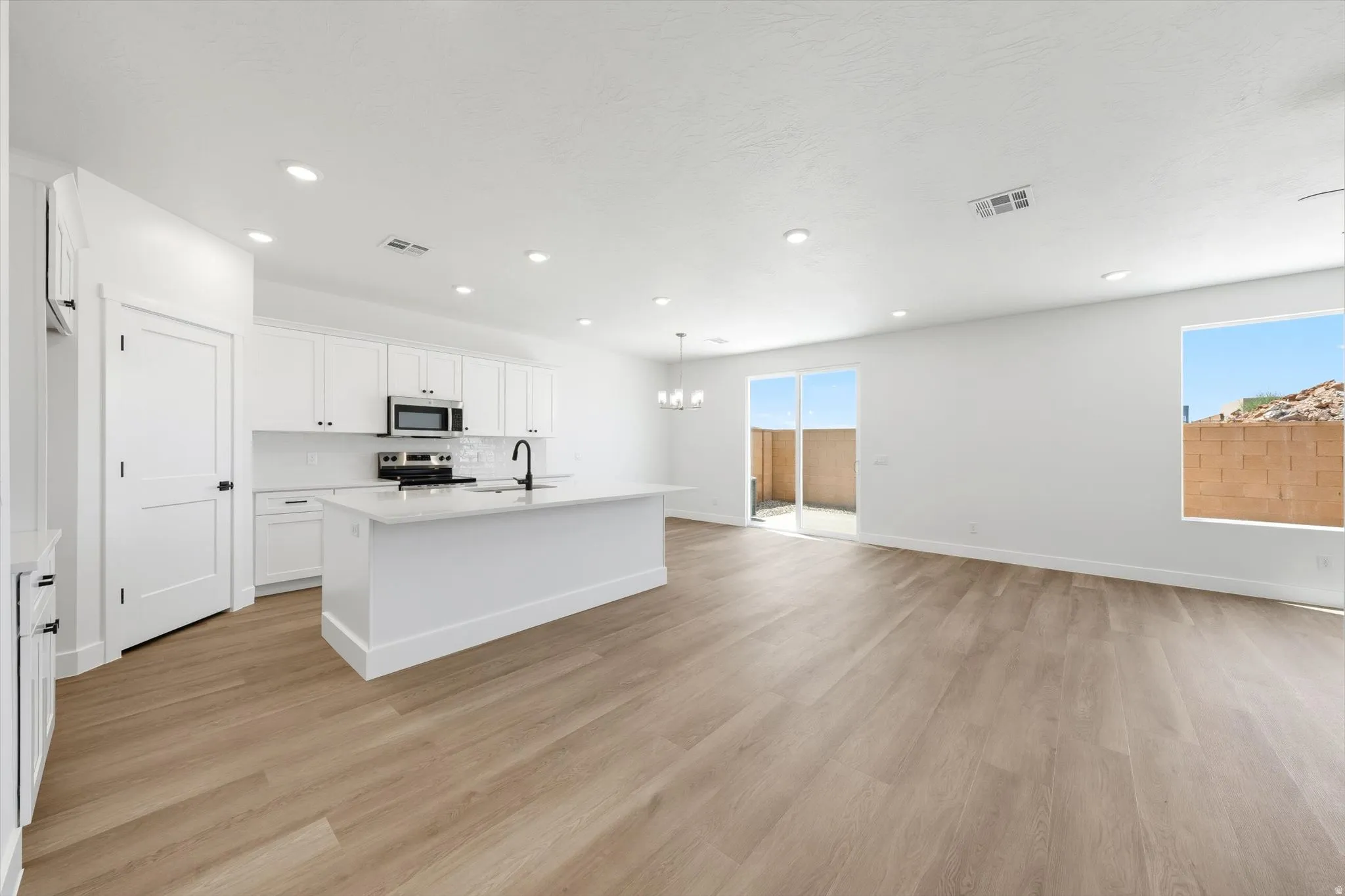 Open-concept living area featuring wood-finish flooring and recessed lighting