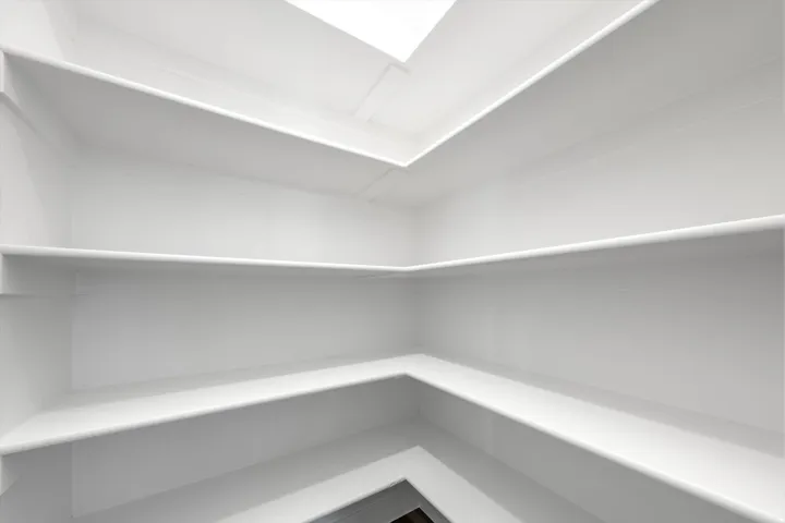 Built-in shelving with multiple levels, white finish, and natural light from above