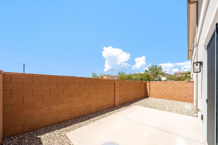 Private patio featuring concrete block walls and gravel landscaping