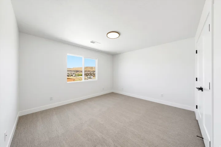 Neutral carpeted flooring, light-toned walls, and a modern ceiling light fixture