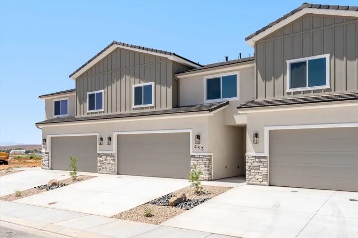 Modern multi-unit townhome community featuring clean-lined architectural design with mixed exterior materials including stone and fiber cement siding