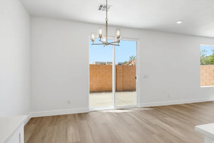 Recessed lighting, wood-finish flooring, and a contemporary chandelier