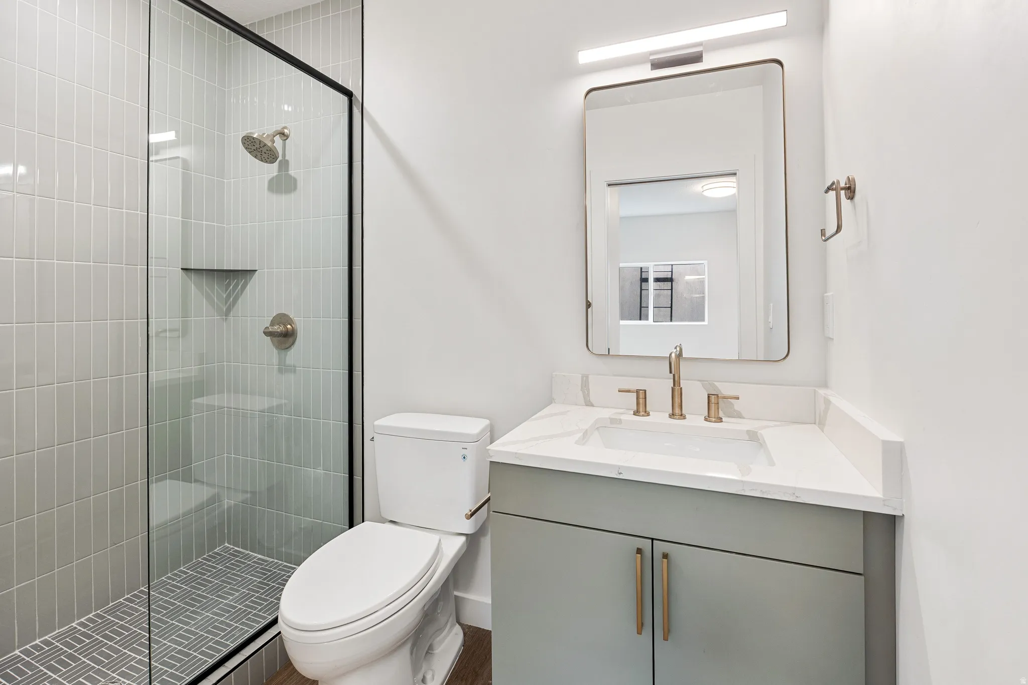 Glass-enclosed shower with vertical tile surround and integrated niche