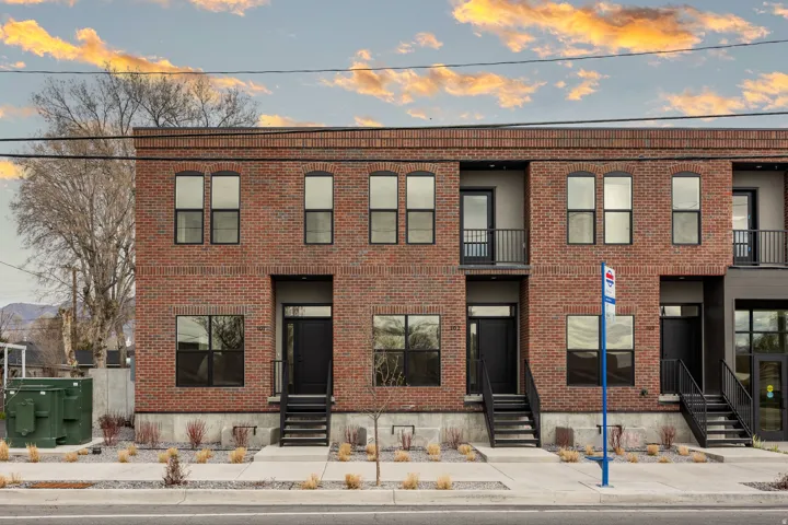 Brick exterior construction, multiple private balconies, ground-level entryways, and modern black-framed windows