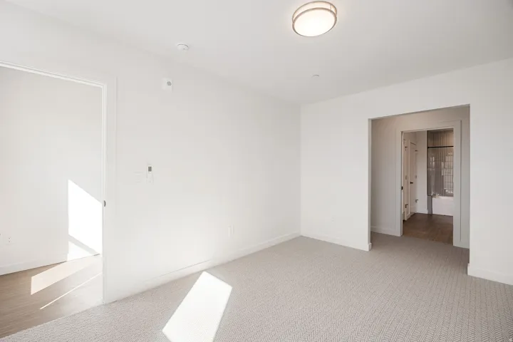 White walls, light-toned carpet, recessed lighting, and a flush mount ceiling fixture