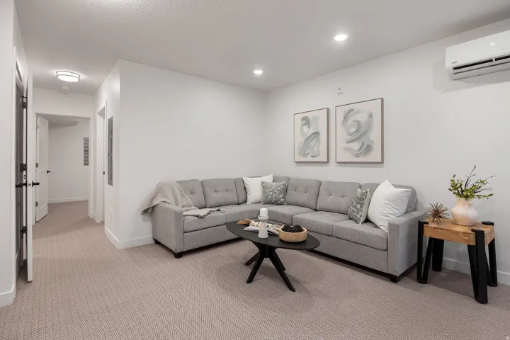Recessed lighting, light-toned carpeting, and a wall-mounted climate control unit