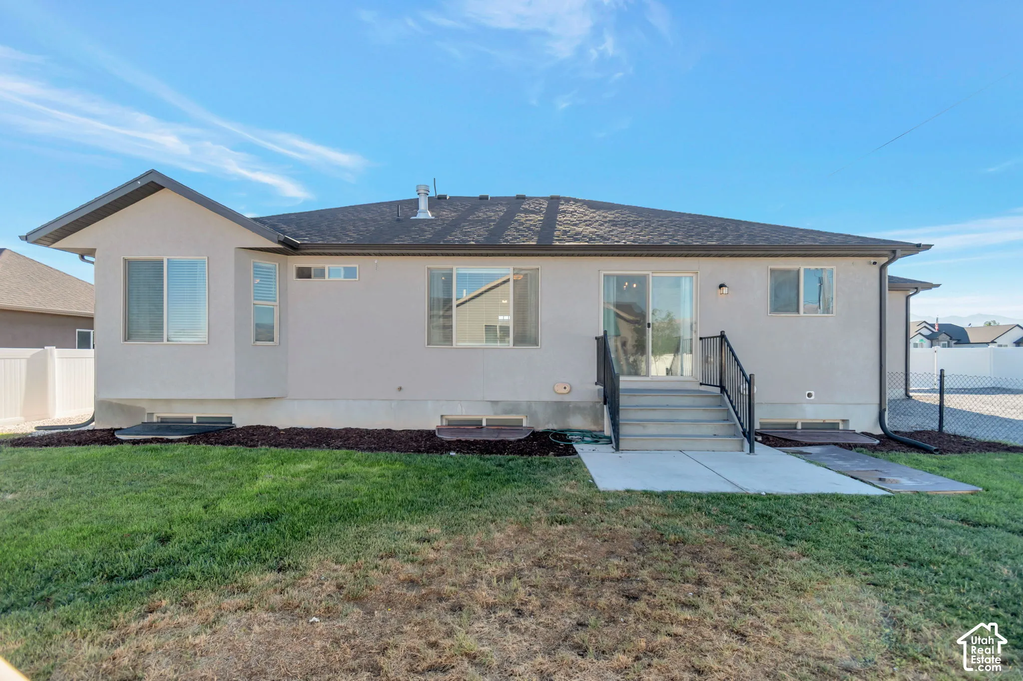 Rear exterior with a concrete patio, sliding glass door, and a bay window