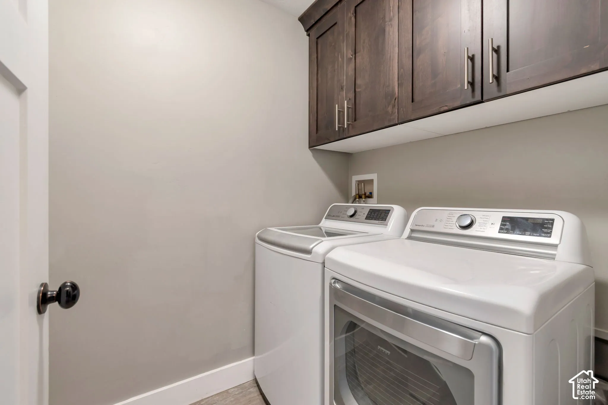 Upper wood-finish cabinetry with silver-tone hardware, providing storage space
