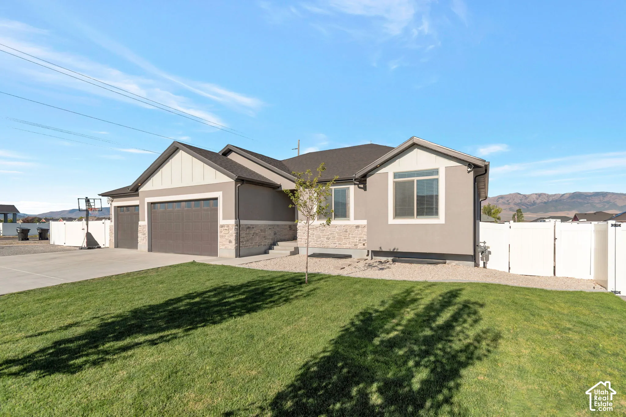 Modern exterior with a two-car garage, concrete driveway, and stone facade accents