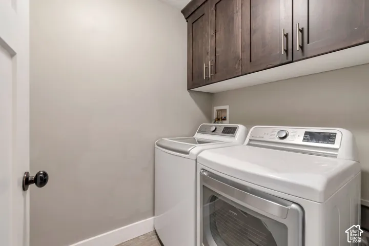 Upper wood-finish cabinetry with silver-tone hardware, providing storage space
