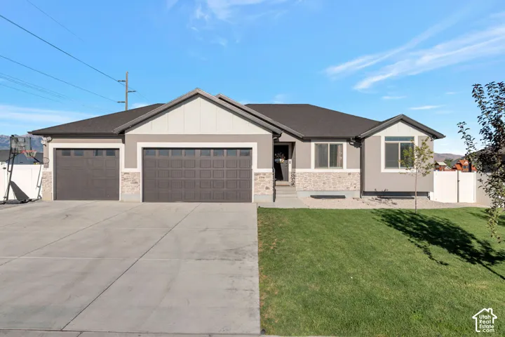 Contemporary exterior with a two-car garage, concrete driveway, and front lawn