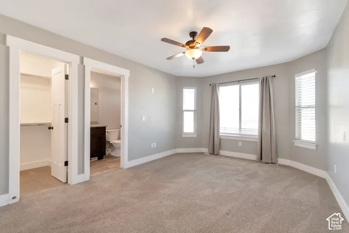 Recessed window alcove with multiple windows, ceiling fan, and light gray wall paint