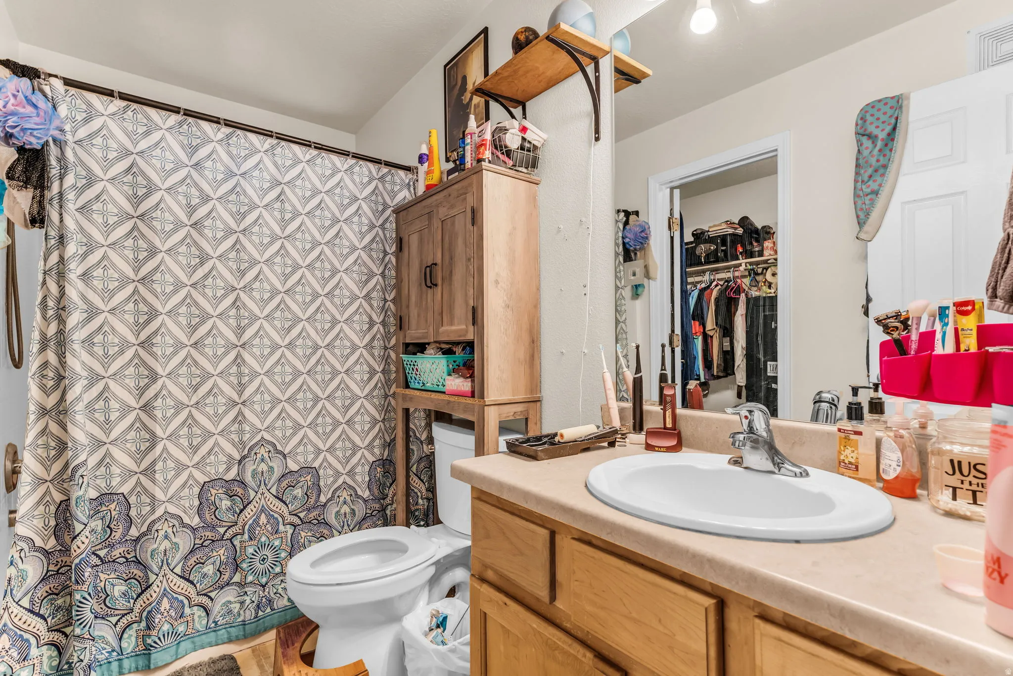 Bathroom featuring a neutral vanity with an integrated sink, chrome faucet, and overhead illumination