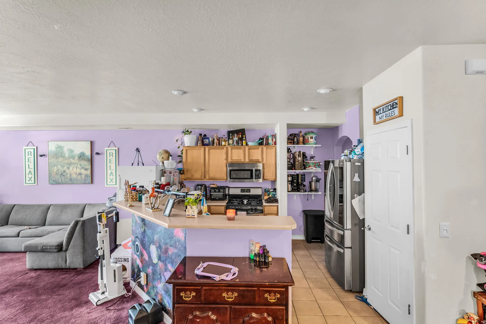 Kitchen featuring wood-finish cabinetry, stainless steel appliances, and a breakfast bar