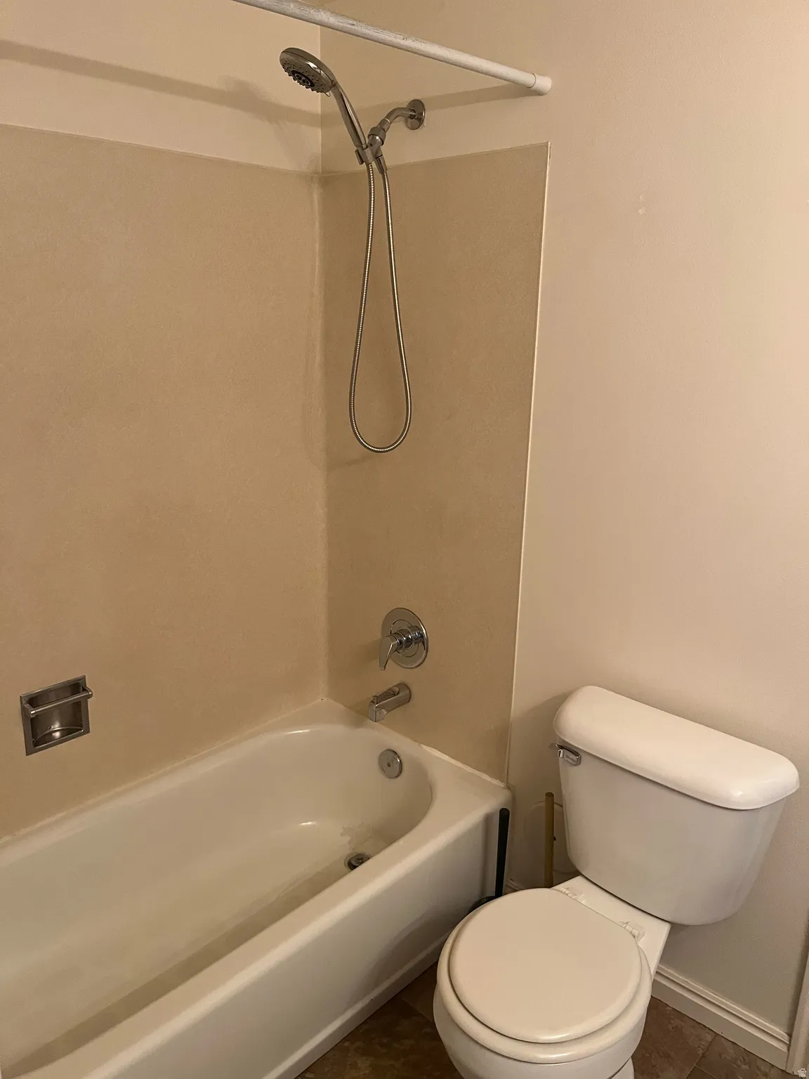 Bathroom featuring a white bathtub, chrome shower fixtures, and a white toilet
