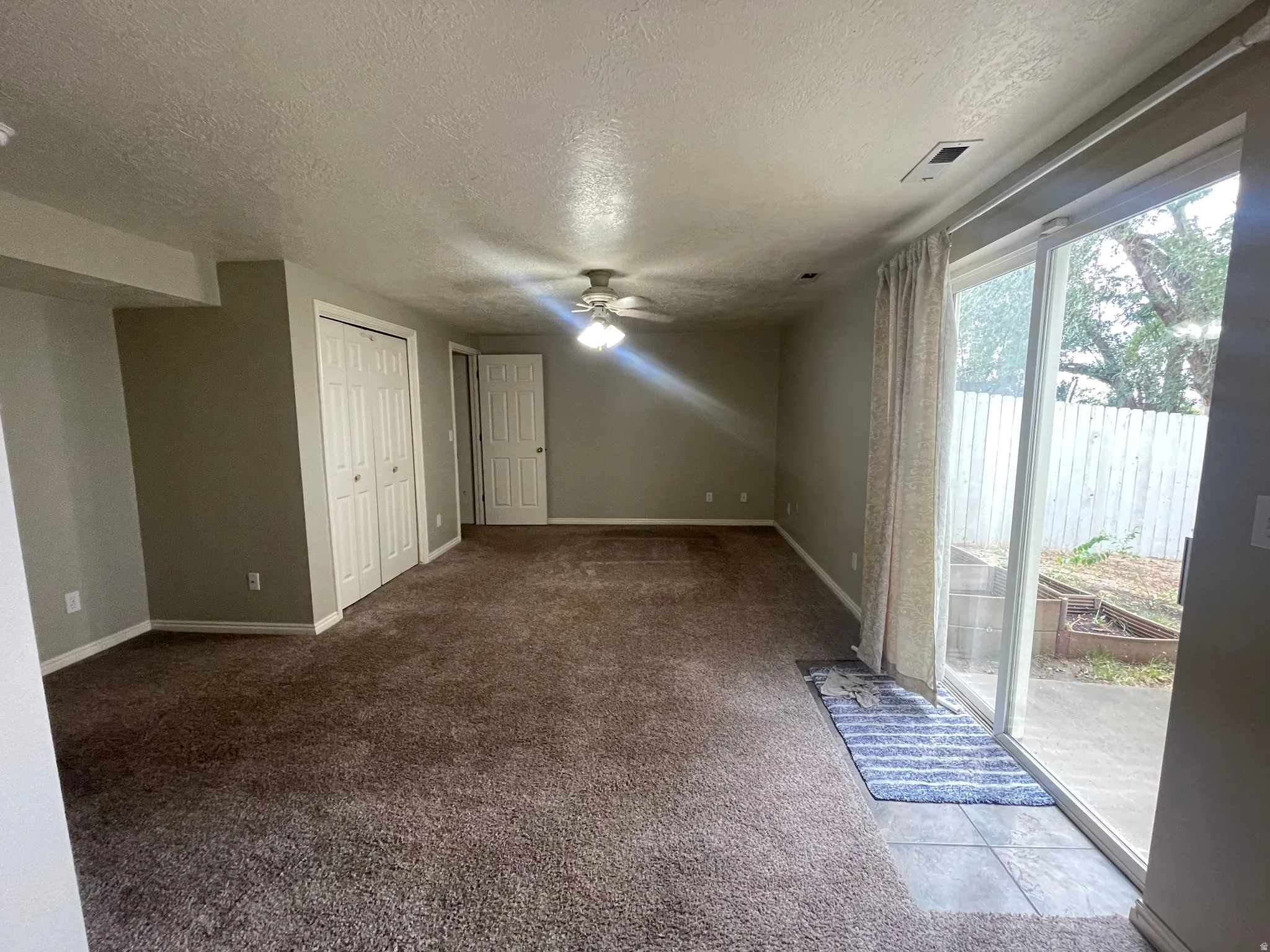 Sliding glass door opening to an outdoor patio with a privacy fence