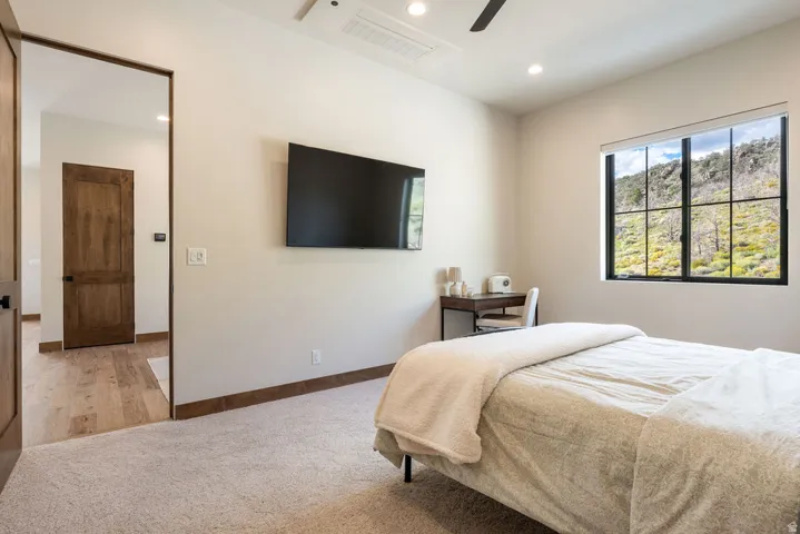 Recessed lighting, ceiling fan, carpet flooring, wood-finish interior doors, and a window with mountain scenery