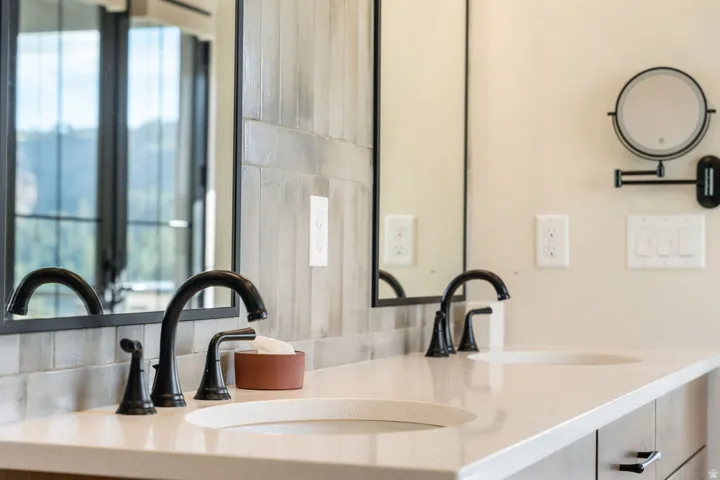 Dual undermount sinks with matte black fixtures, set into a light-toned countertop