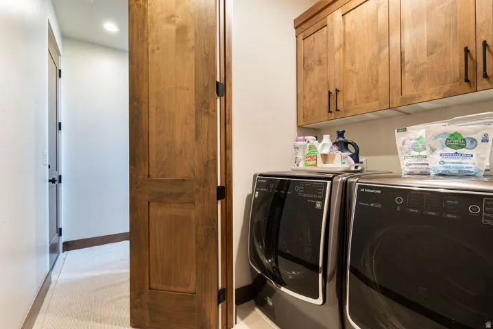 Hallway laundry area featuring wood-finish cabinetry, a built-in counter, and recessed lighting