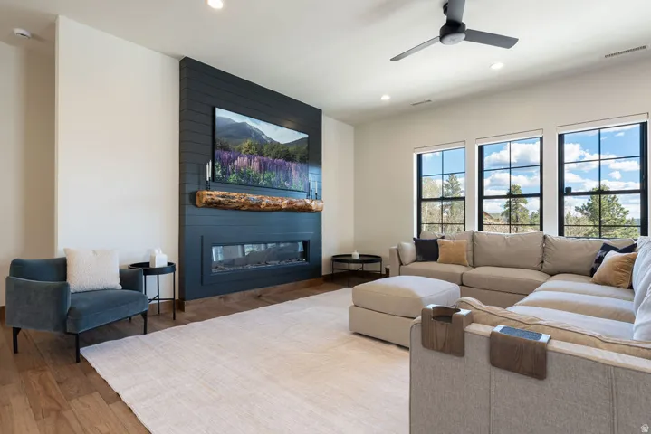 High ceilings with recessed lighting, wood-finish flooring, and a ceiling fan