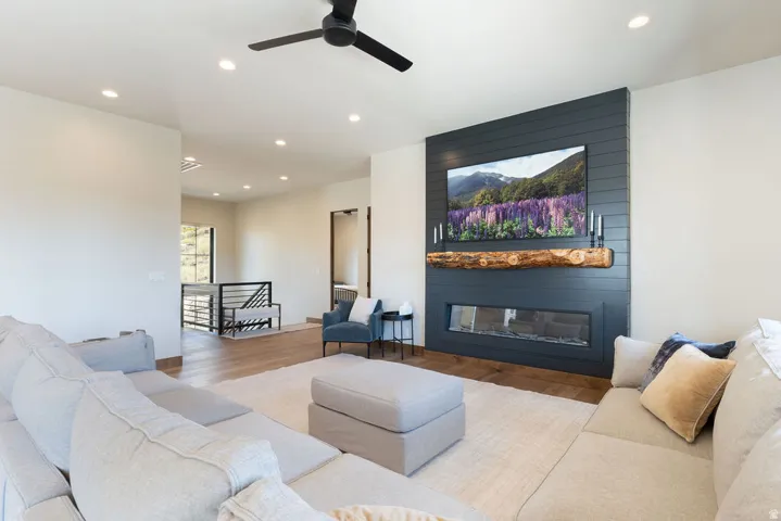 Shiplap accent wall with a linear fireplace and a rustic wood mantel