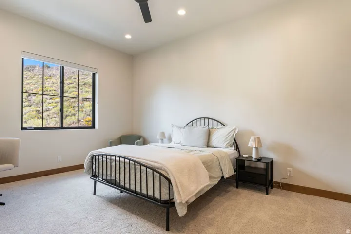 Recessed lighting, ceiling fan, large window with black grid panes, and wood-finish trim