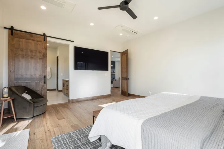Wood-finish flooring, recessed lighting, and a black ceiling fan