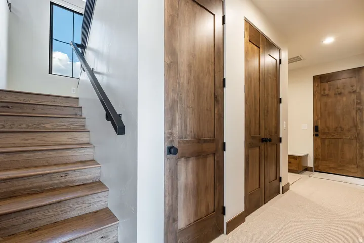 Wood-finish staircase with black metal handrail