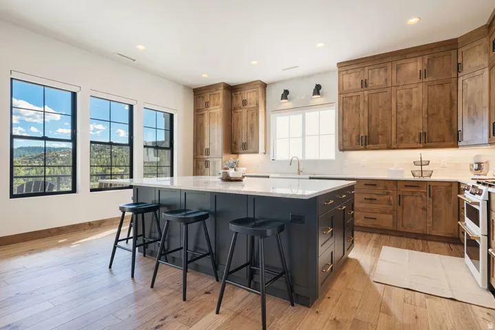 Kitchen featuring wood-finish flooring, recessed lighting, and a center island with a light-toned countertop