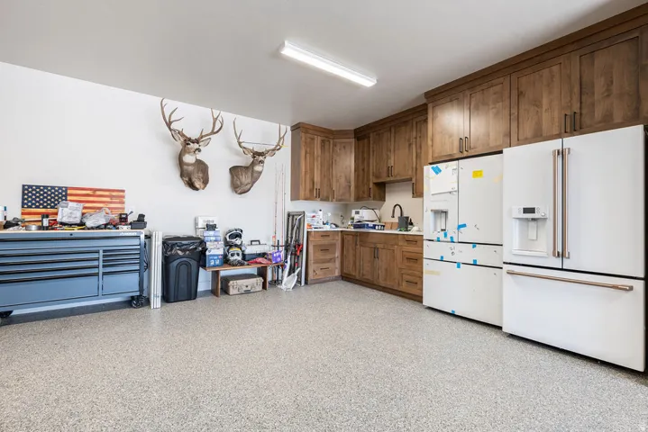 Epoxy-finished flooring, wood-finish cabinetry, built-in countertop, and fluorescent lighting