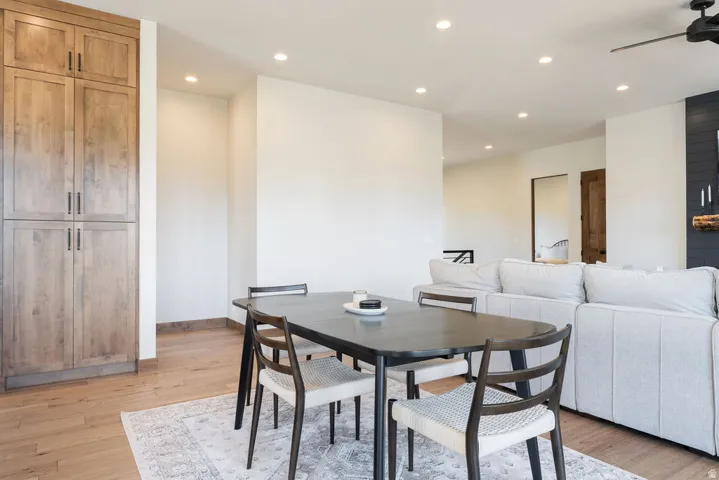 Open-concept living area featuring wood-finish flooring, recessed lighting, and built-in cabinetry with dark hardware
