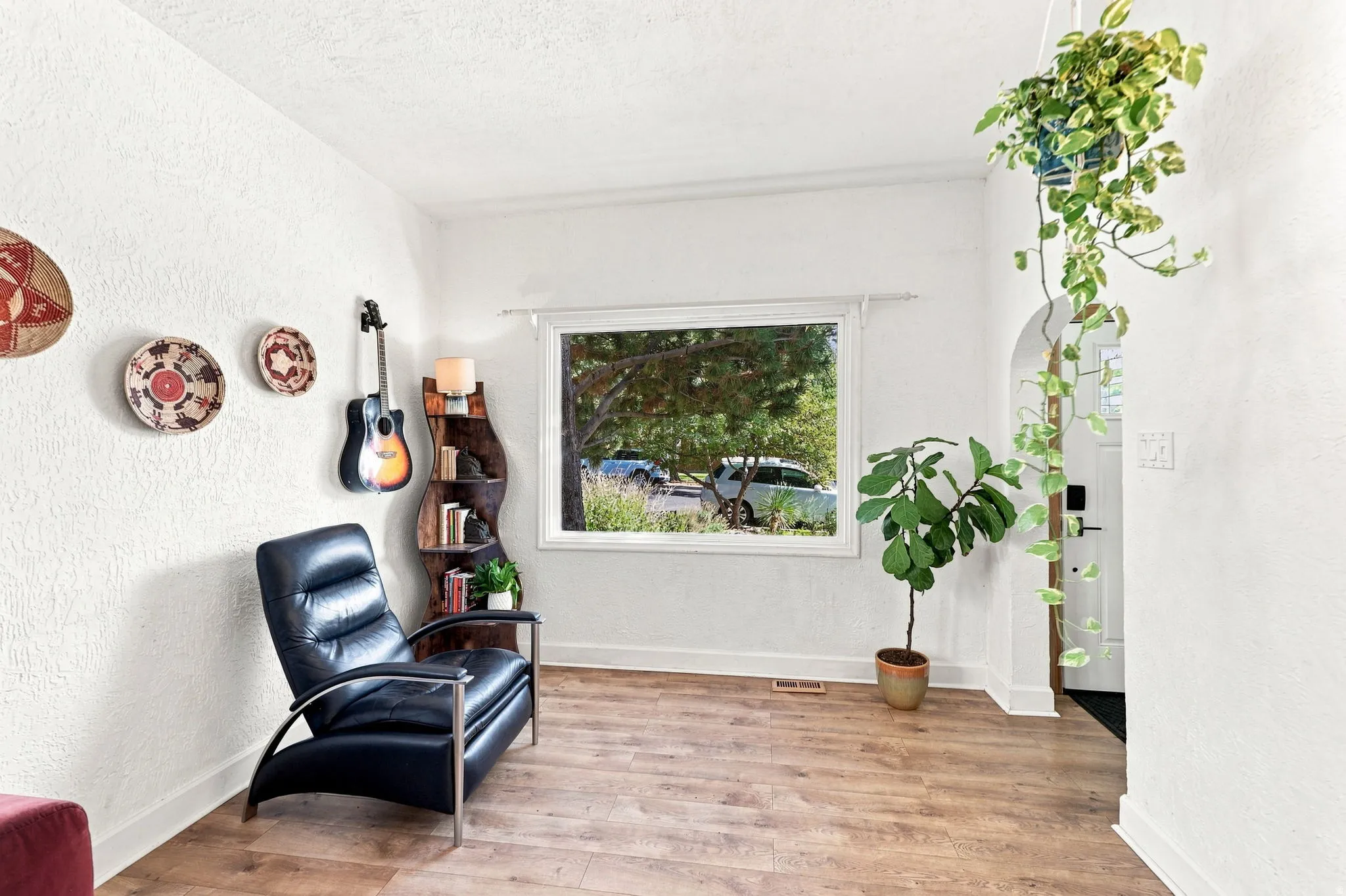 Wood-finish flooring, white painted walls, and a large window with white trim
