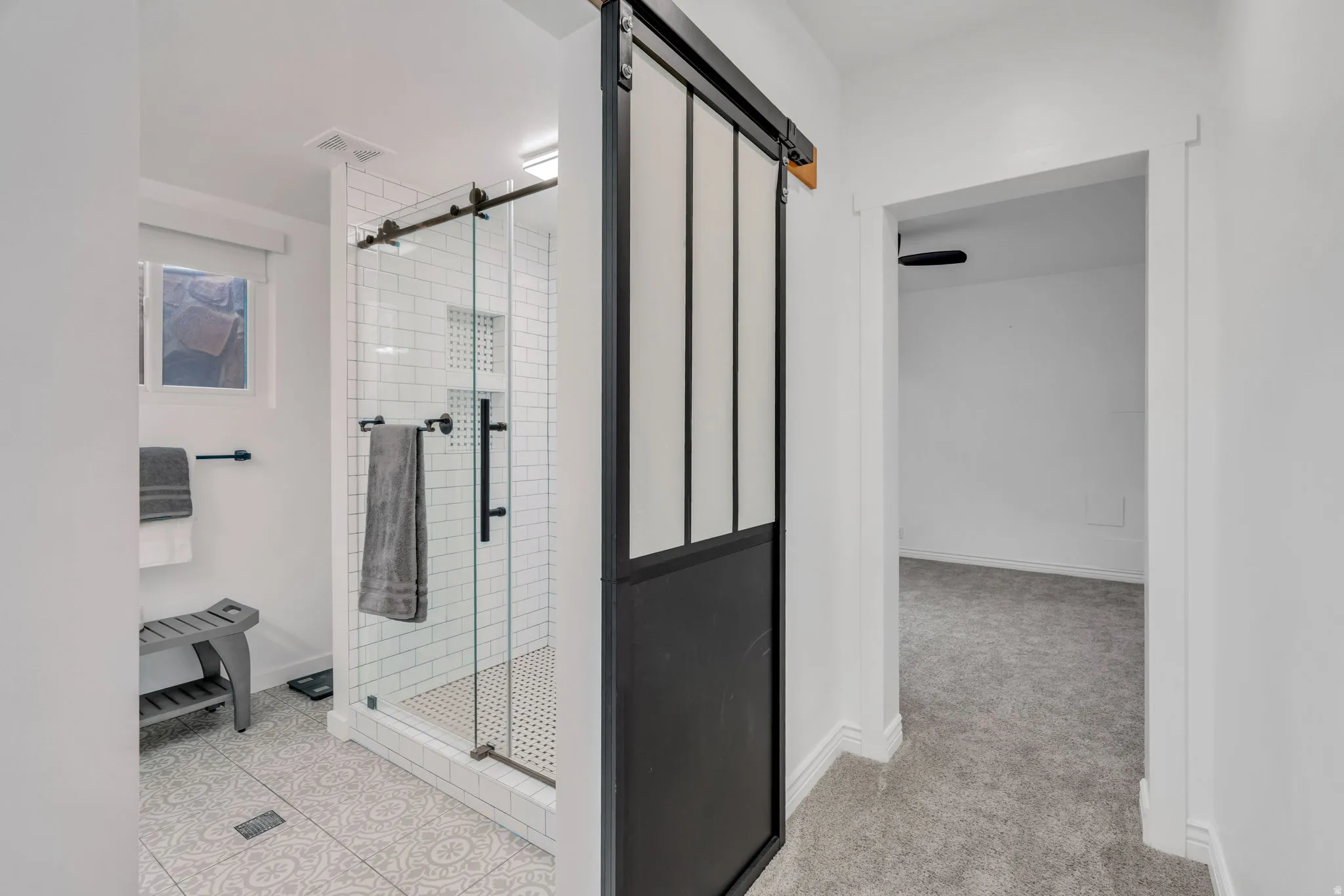 Custom updates shine in this basement bath, from the sleek Euro-style shower to the distinctive sliding barn door.