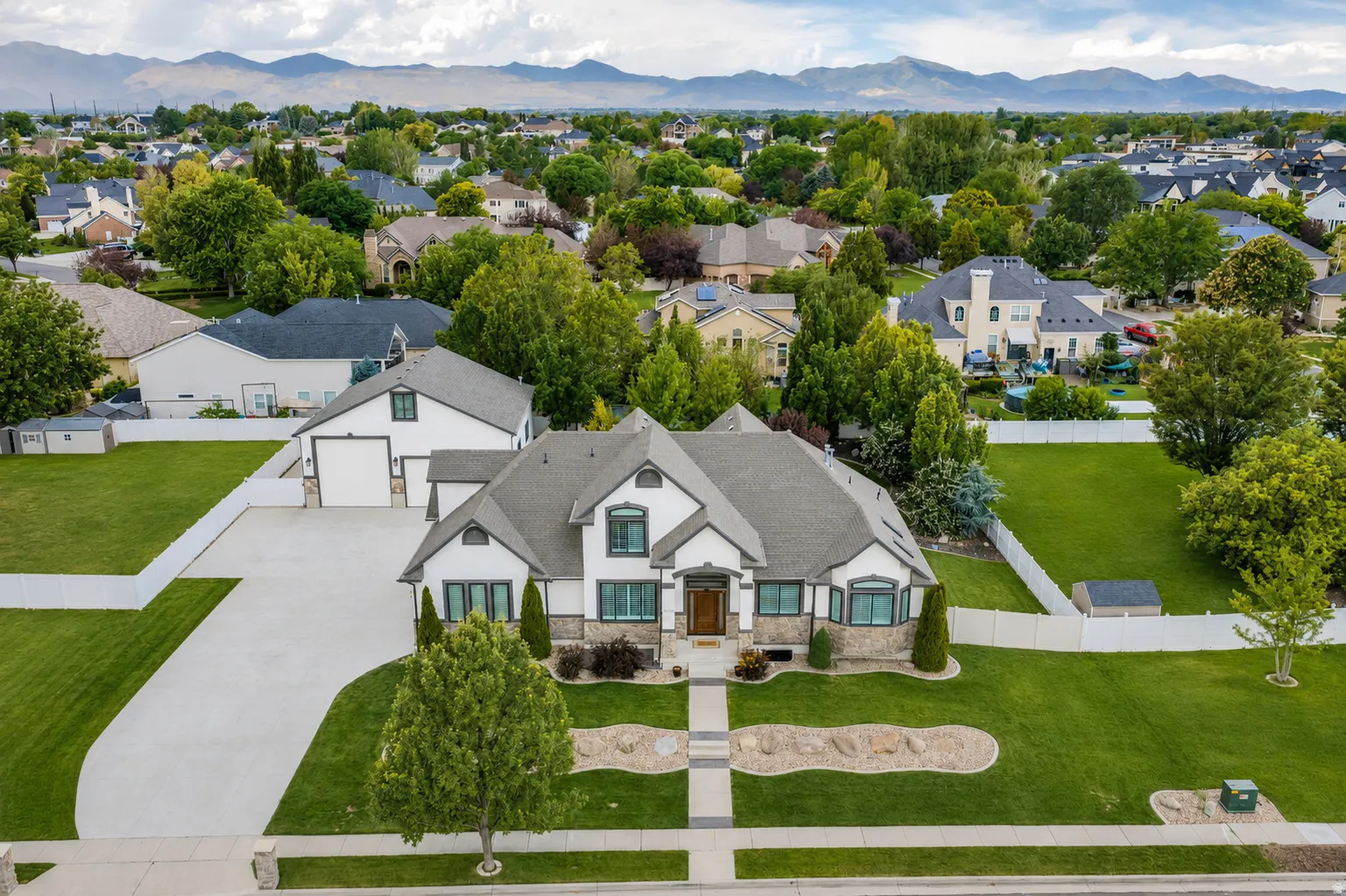 Spacious property featuring a large driveway, established landscaping, and a well-maintained exterior