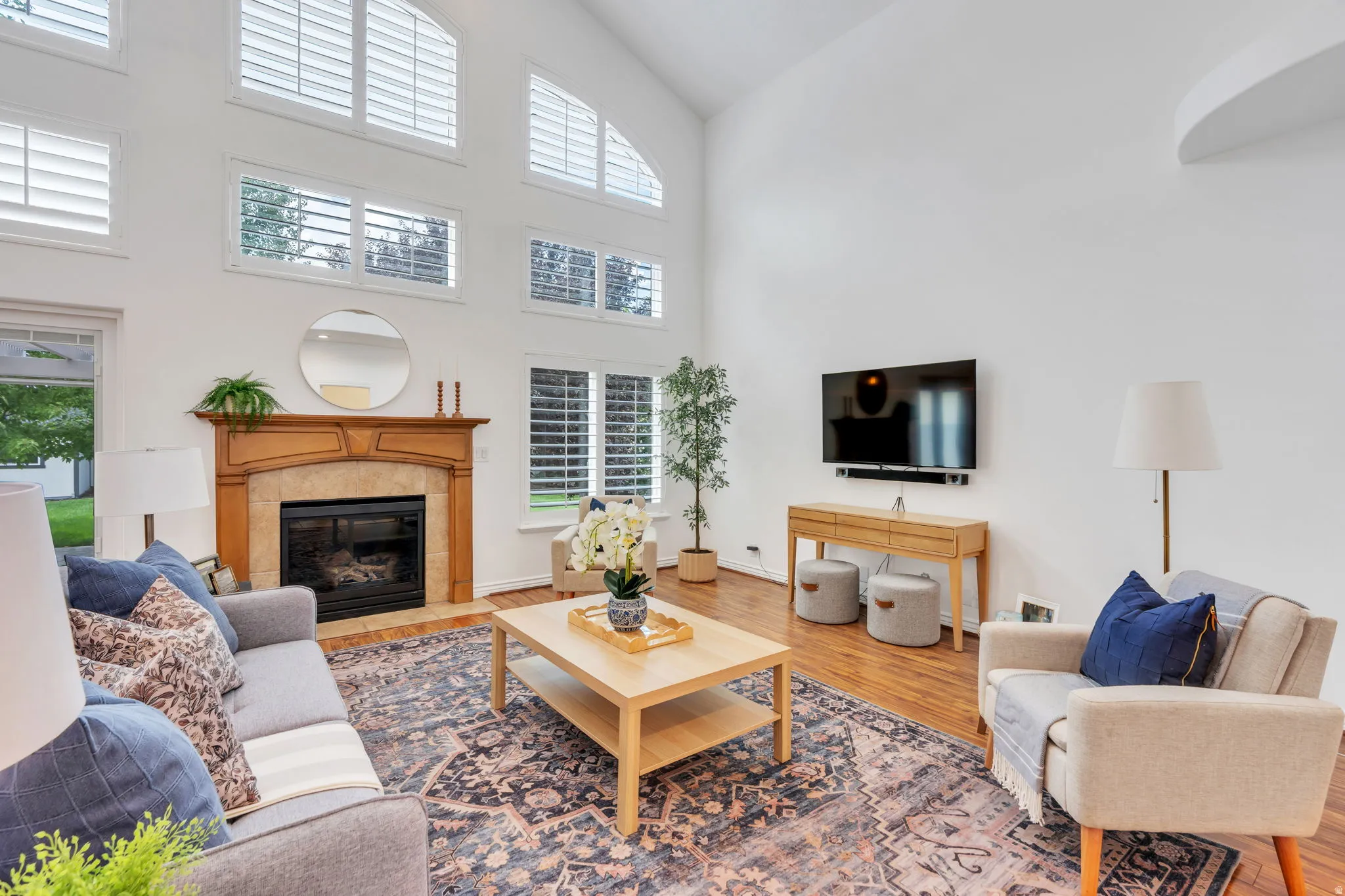 An impressive great room designed for gathering, with soaring ceilings, expansive windows, and an open connection to the kitchen and dining areas.