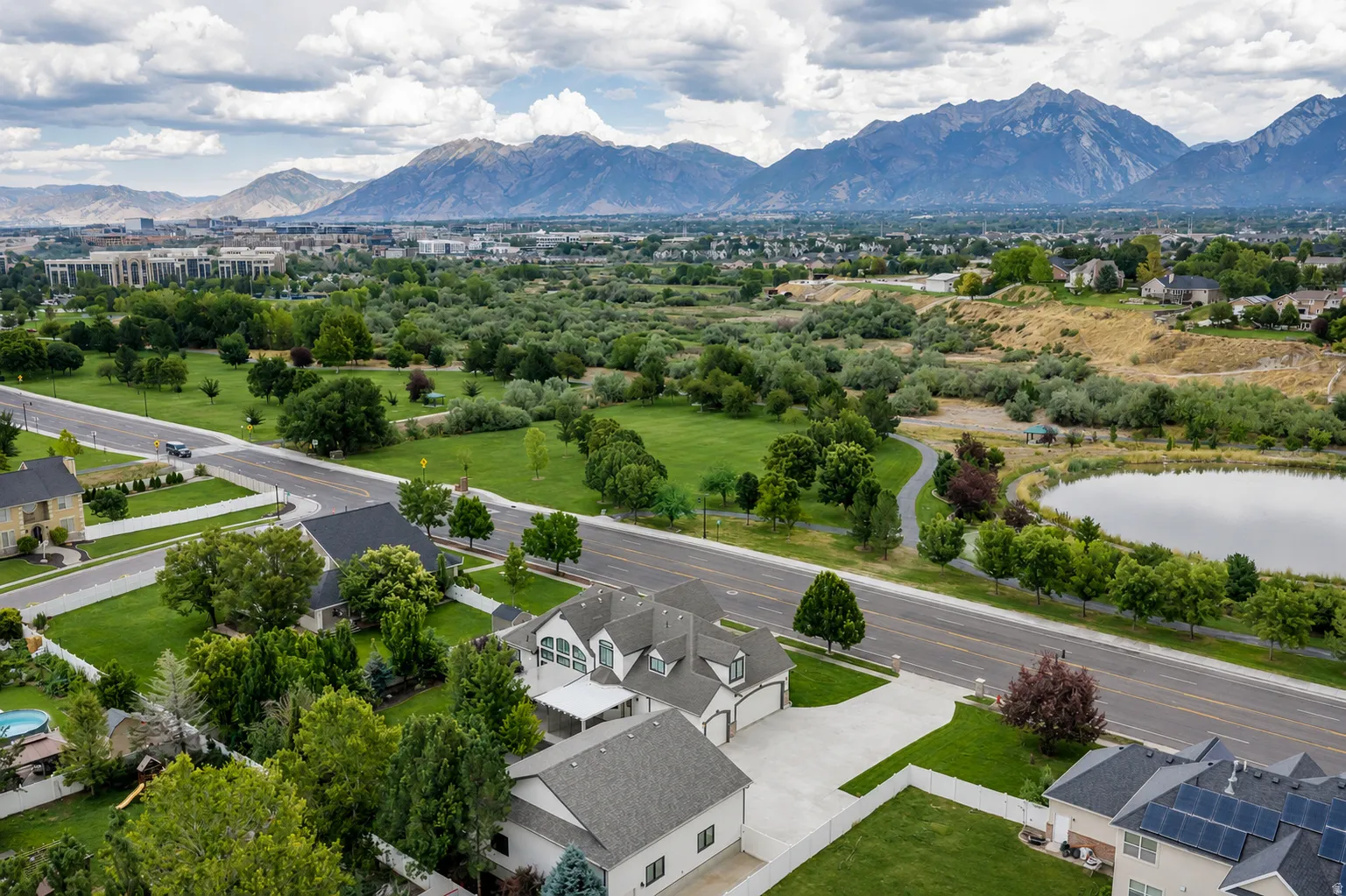 Aerial perspective showcasing a residential property with a multi-car driveway and a manicured lawn