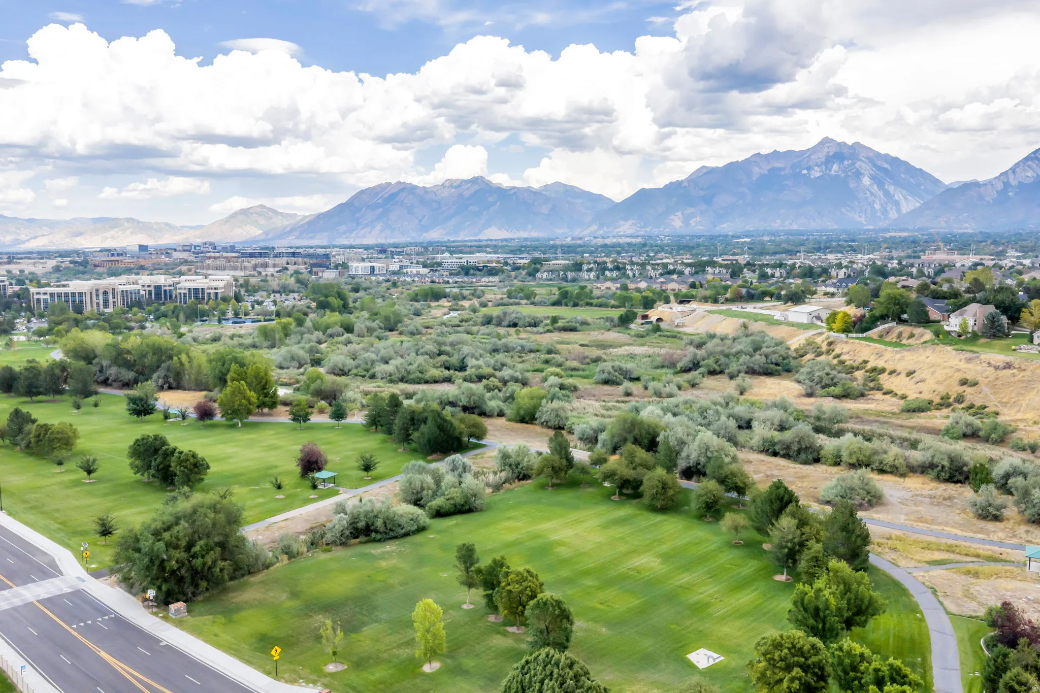 Expansive green spaces and mature trees complement the mountain backdrop