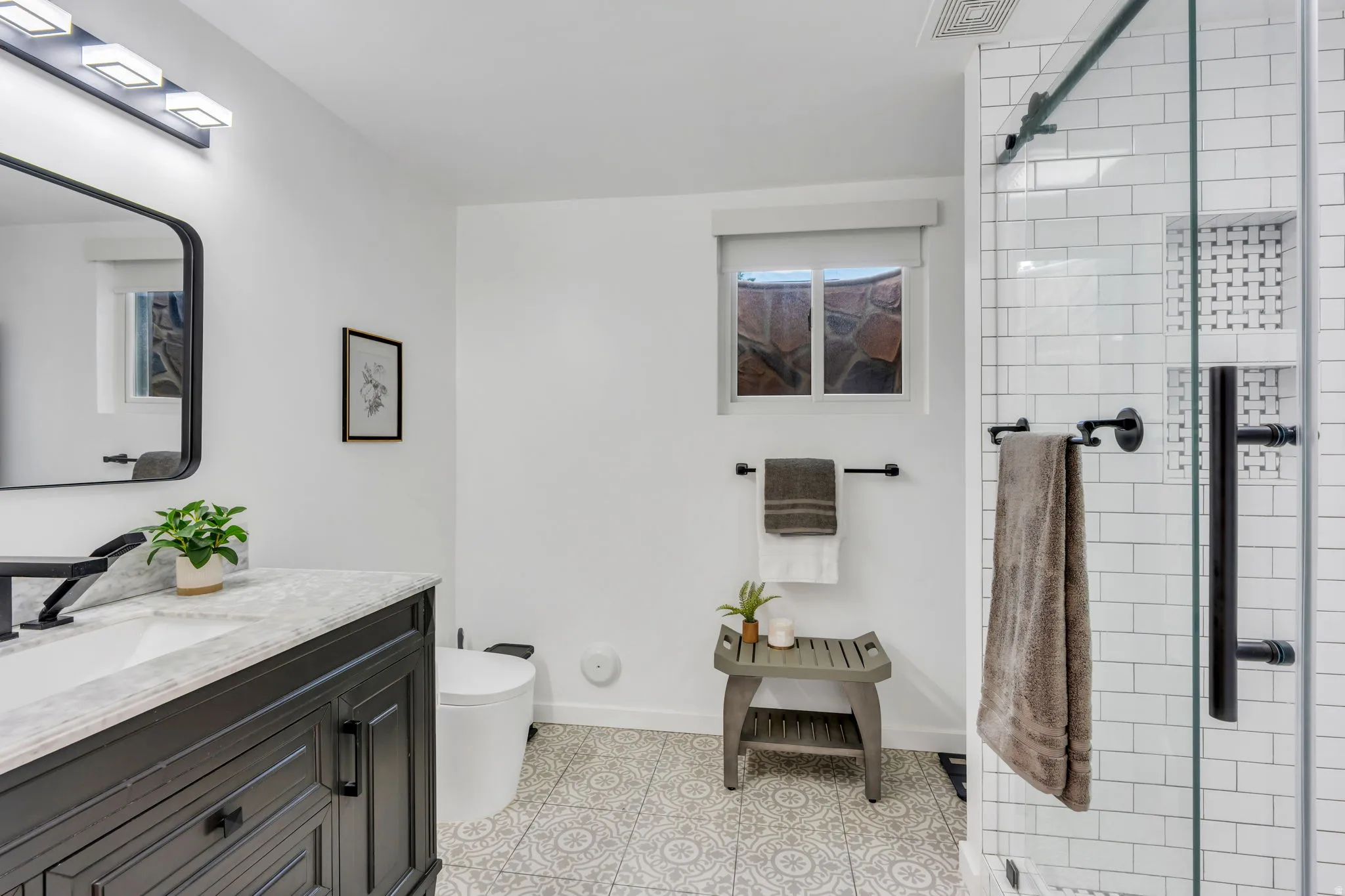 Beautifully updated lower-level bathroom featuring a gorgeous custom Euro-style shower with sleek glass enclosure and designer finishes.