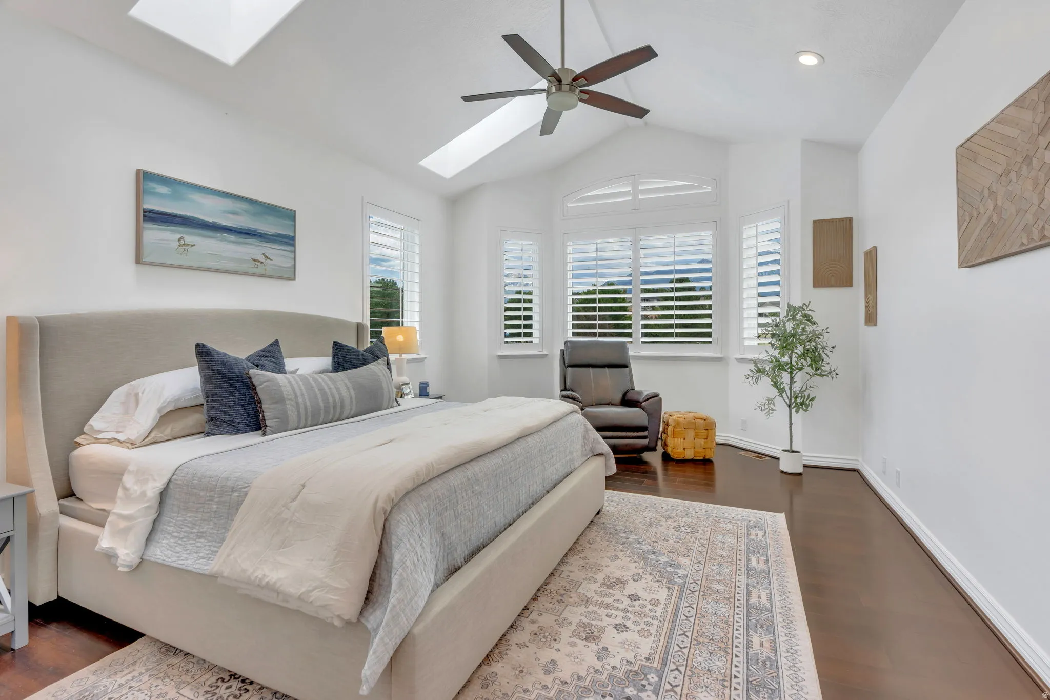 Beautiful primary suite with a vaulted ceiling, skylights, updated floors, and walls of windows with mountain views that fill the room with natural light.