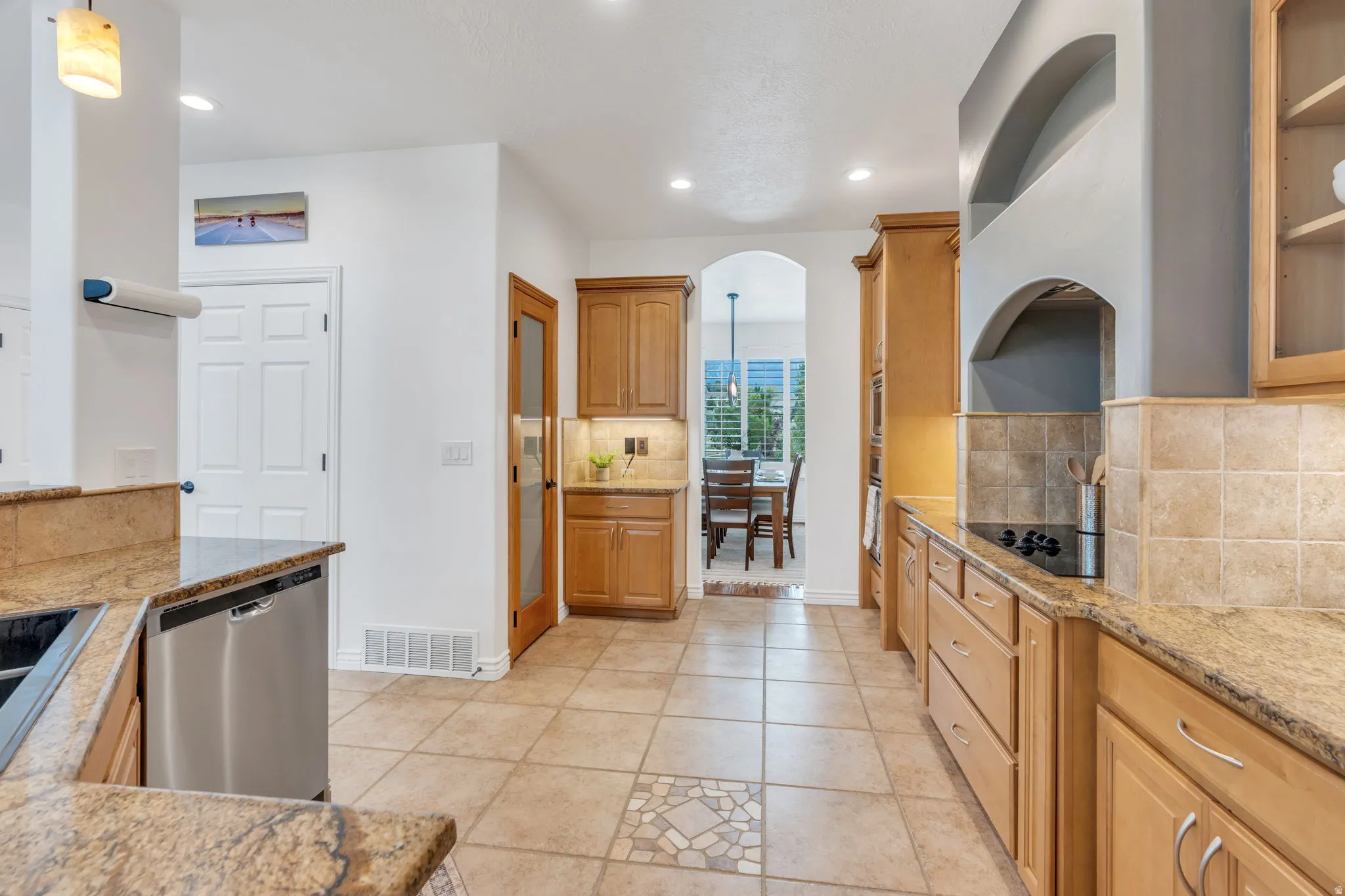 Kitchen featuring light wood cabinetry, stone countertops, and tile flooring
