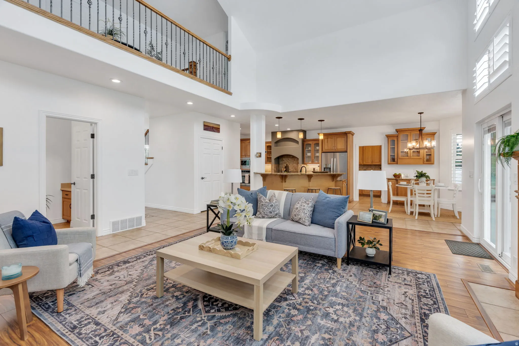 Soaring ceilings, hardwood flooring, and a kitchen with warm wood cabinetry