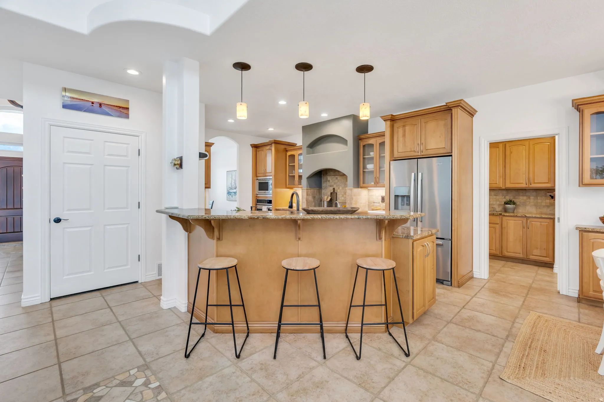 Kitchen island featuring a built-in sink and pendant lighting